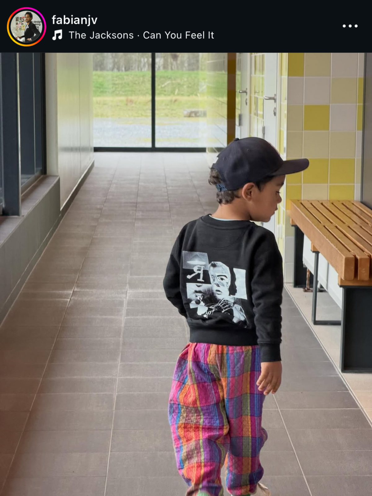 Child wearing a black jumper with white collage print