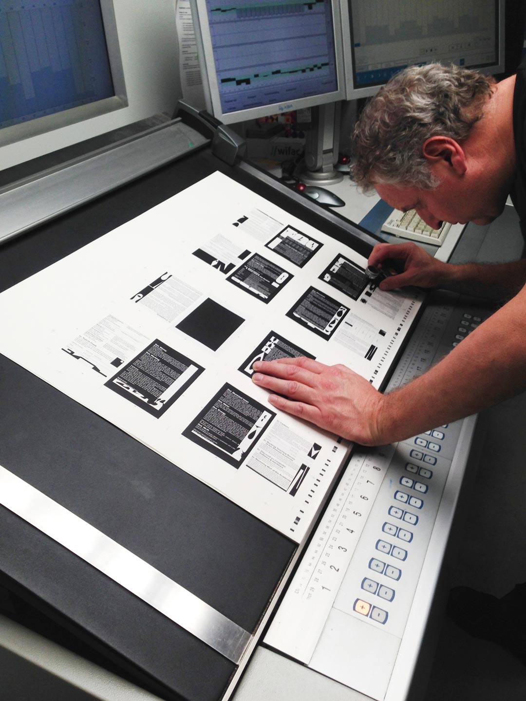Printer looking closely at the details of a freshly printed sheet