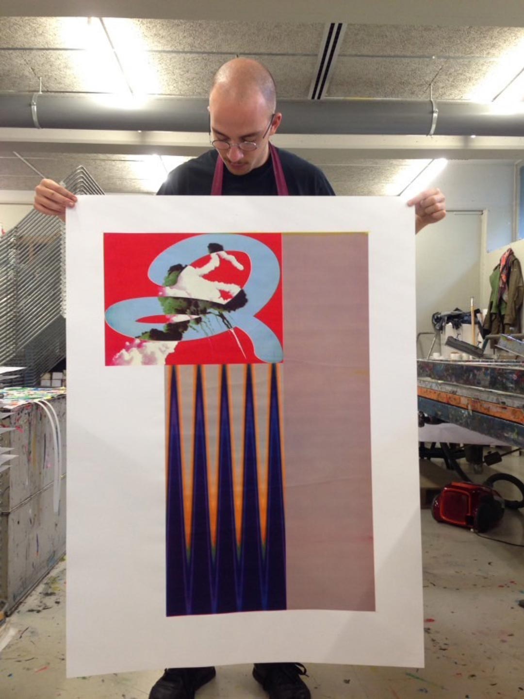 Person holding a silkscreen screen in a printing workshop